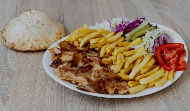 doner kebab served with french fries, tomatoes and rice pilaf