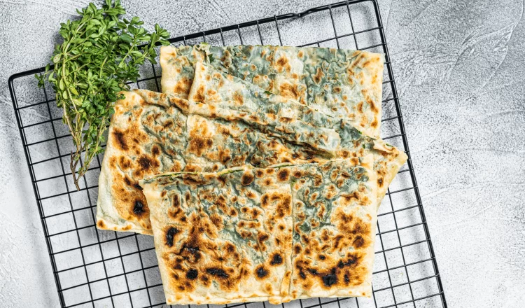 flatbread cut into pieces with greens