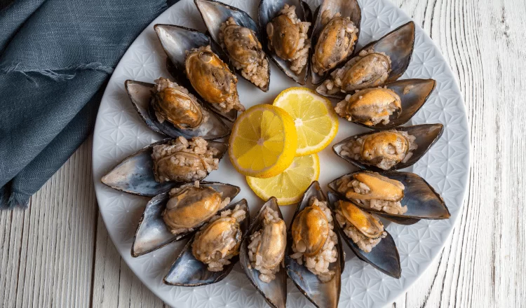 stuffed mussels lined up with a cut lemon in the middle