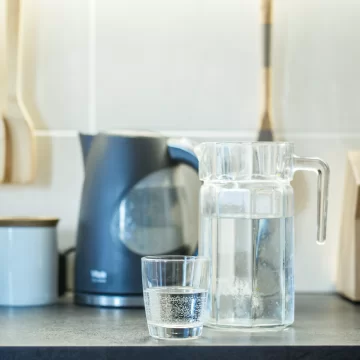 A jug of water and glass standing on the table